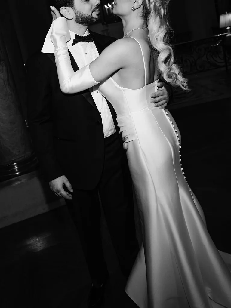 Black-and-white photograph of a bride and groom embracing during their first dance, photographed by Jérémy Froeliger