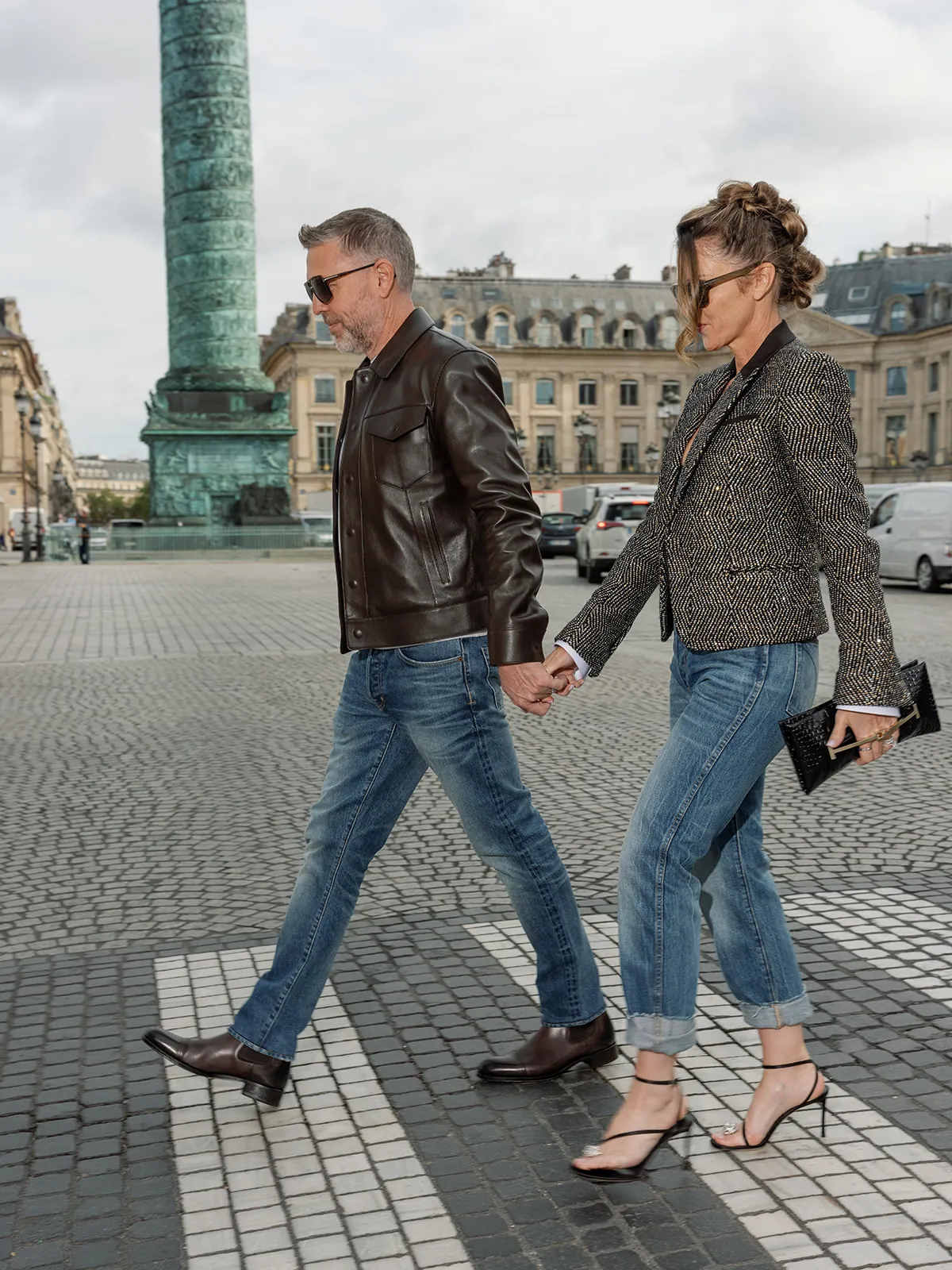Deux personnes marchant main dans la main près de la colonne Vendôme