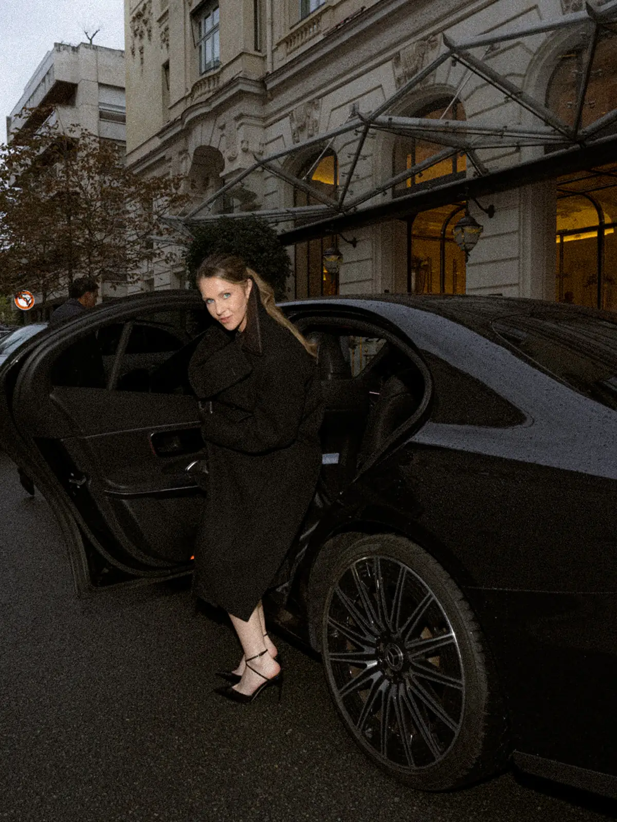 Portrait de mode près d’une voiture devant l’hôtel