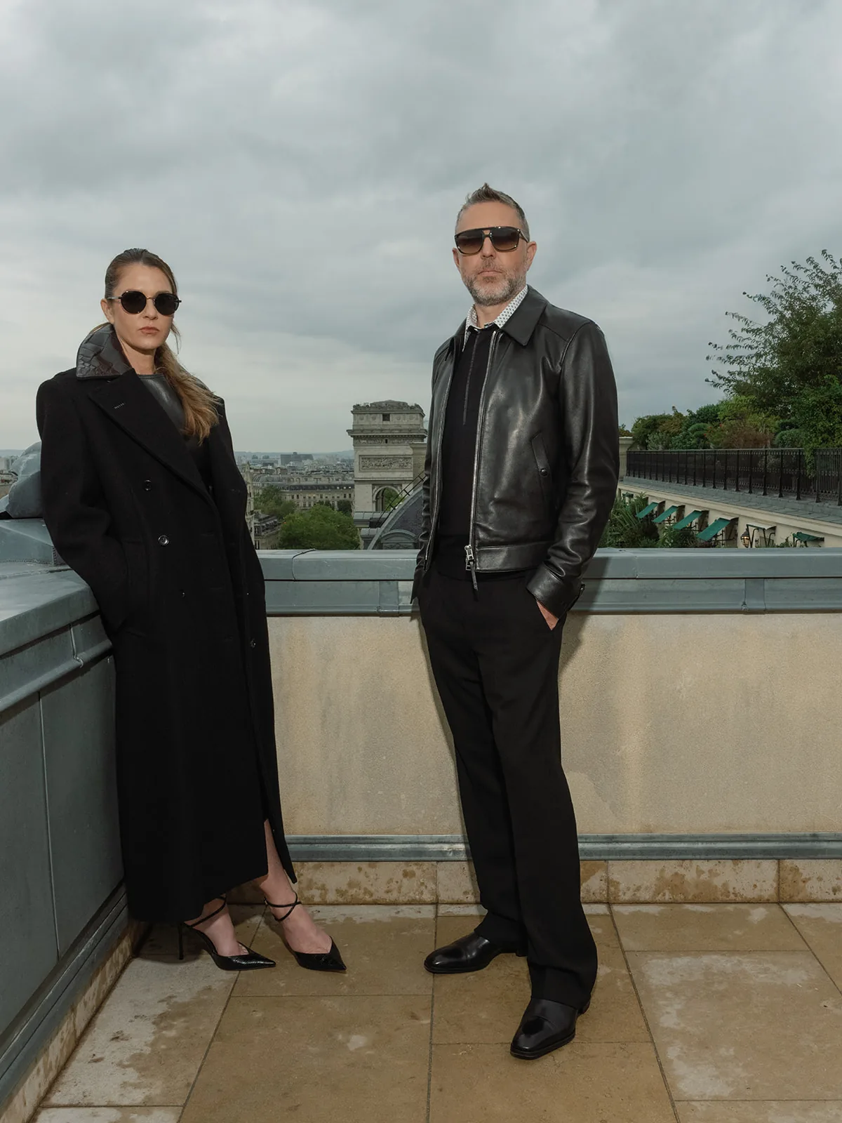 Portrait en pied de deux personnes en tenues sombres Tom Ford