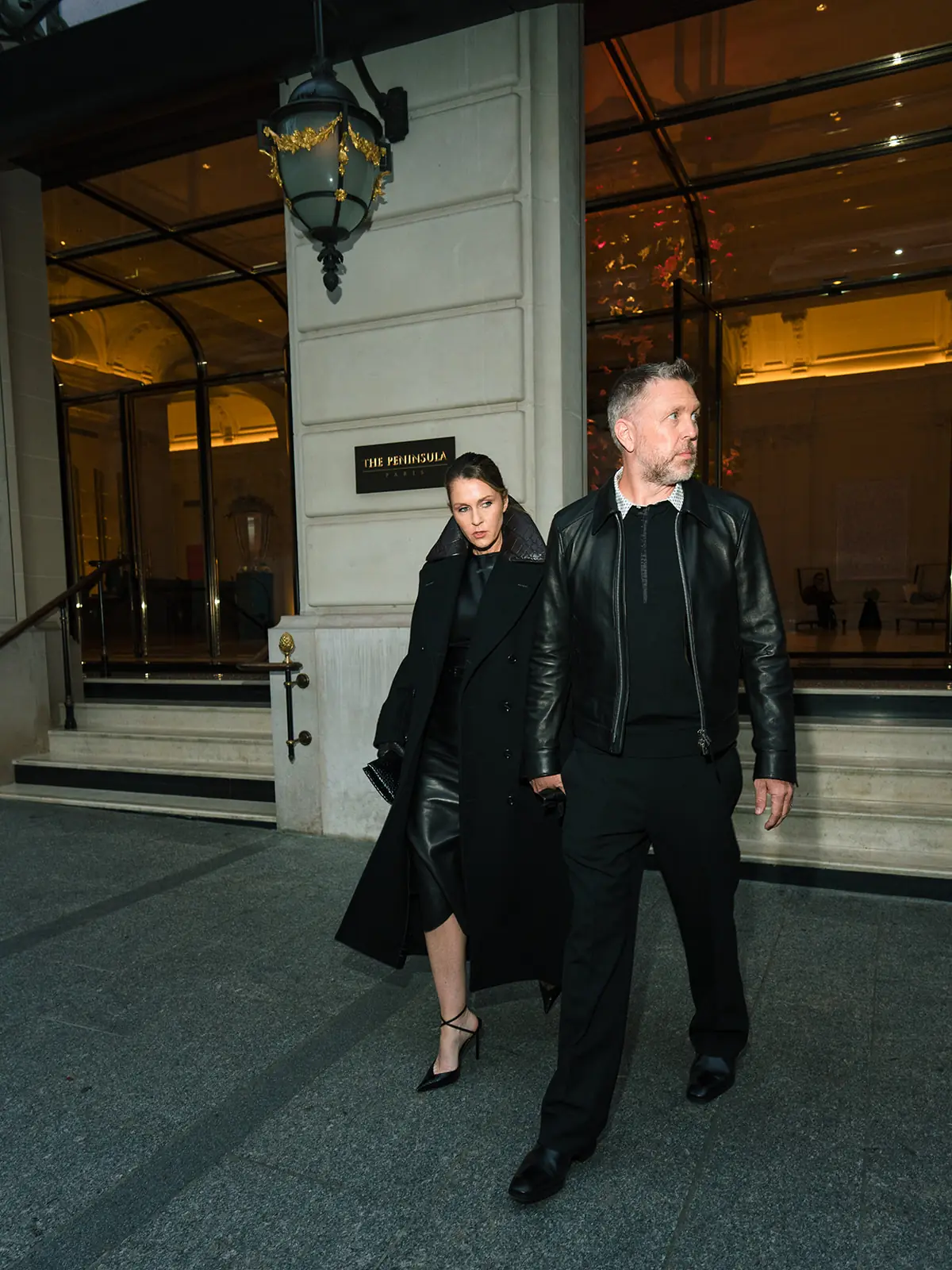 Couple leaving the hotel in dark Tom Ford outfits