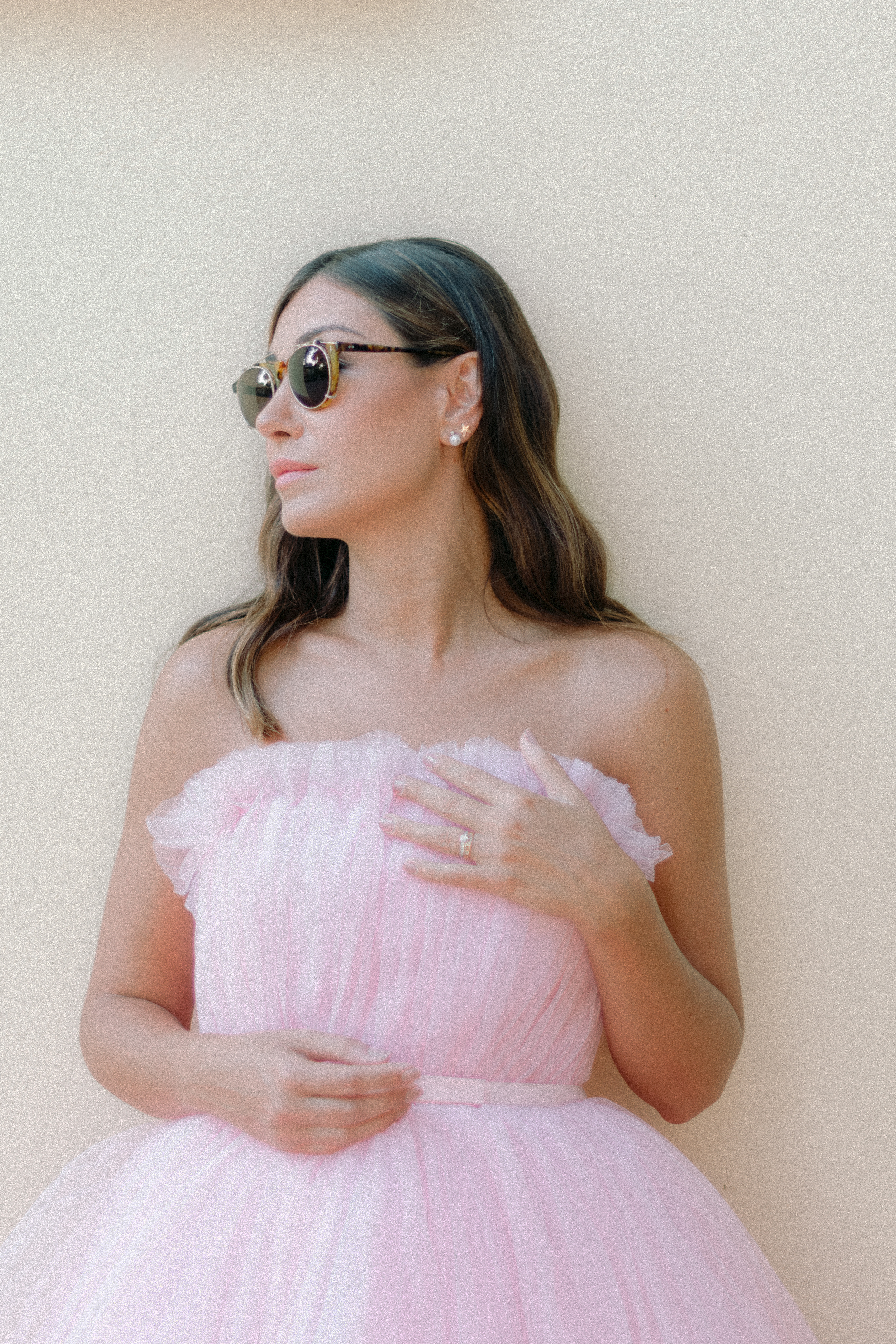 une mariée en robe rose et lunette de soleil pose mode