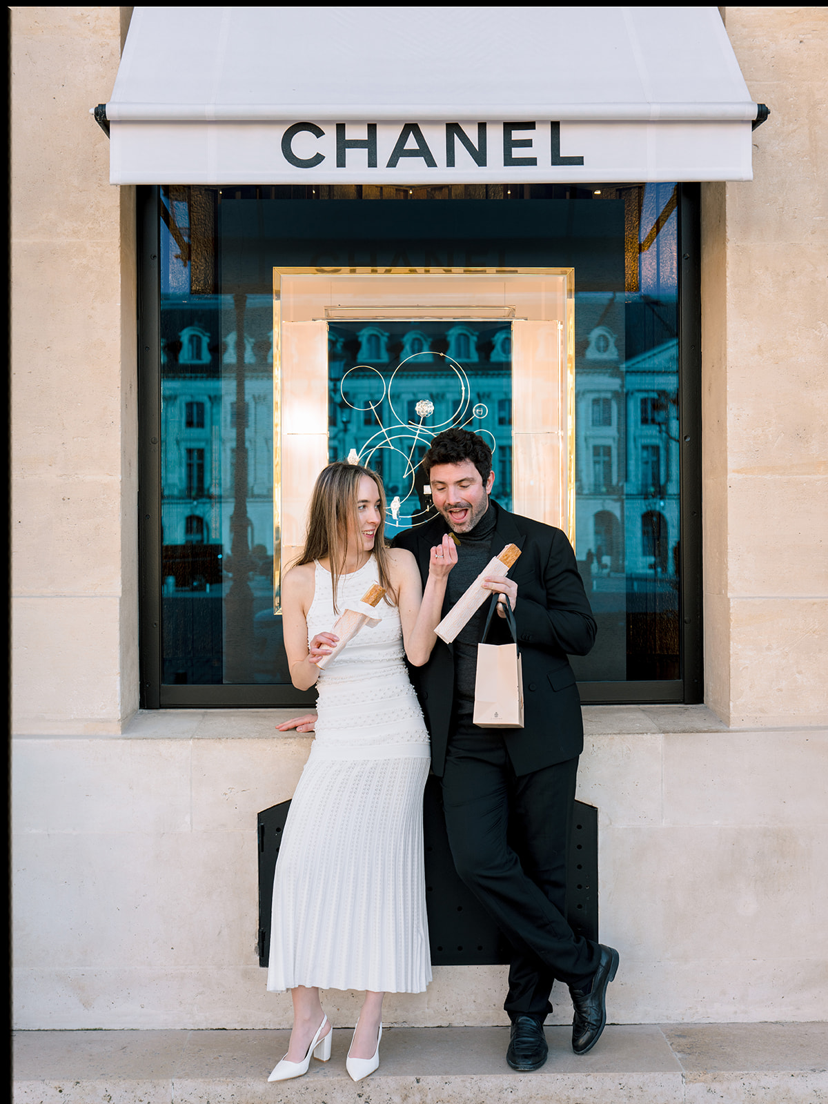 Editorial couple enjoying pastries outside Chanel on Rue Cambon in Paris