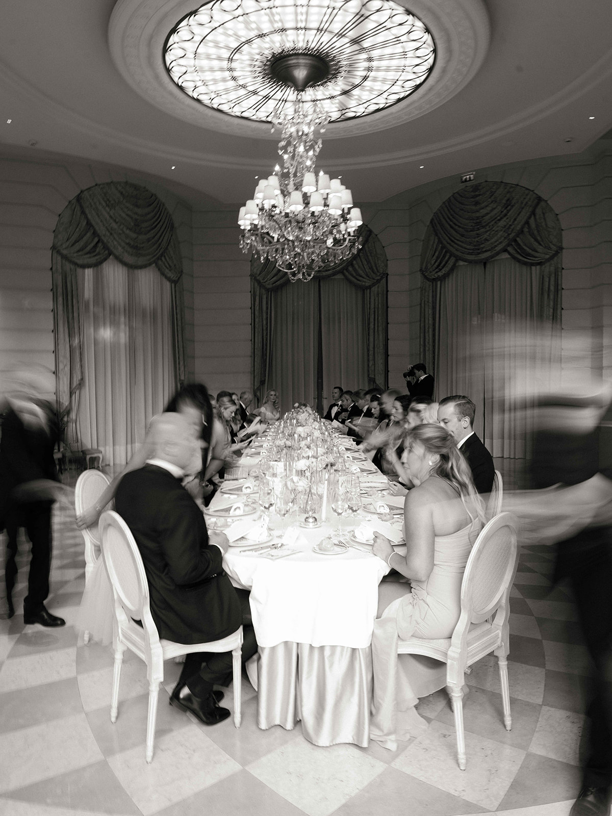 Dîner de mariage en noir et blanc dans un salon du Ritz Paris sous un lustre en cristal