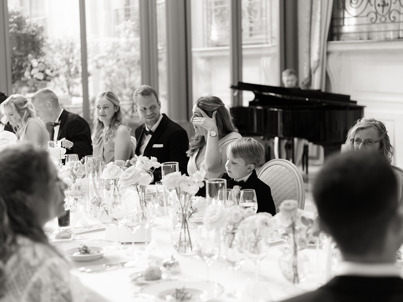 Invités souriant pendant les discours d'une réception de mariage à Paris