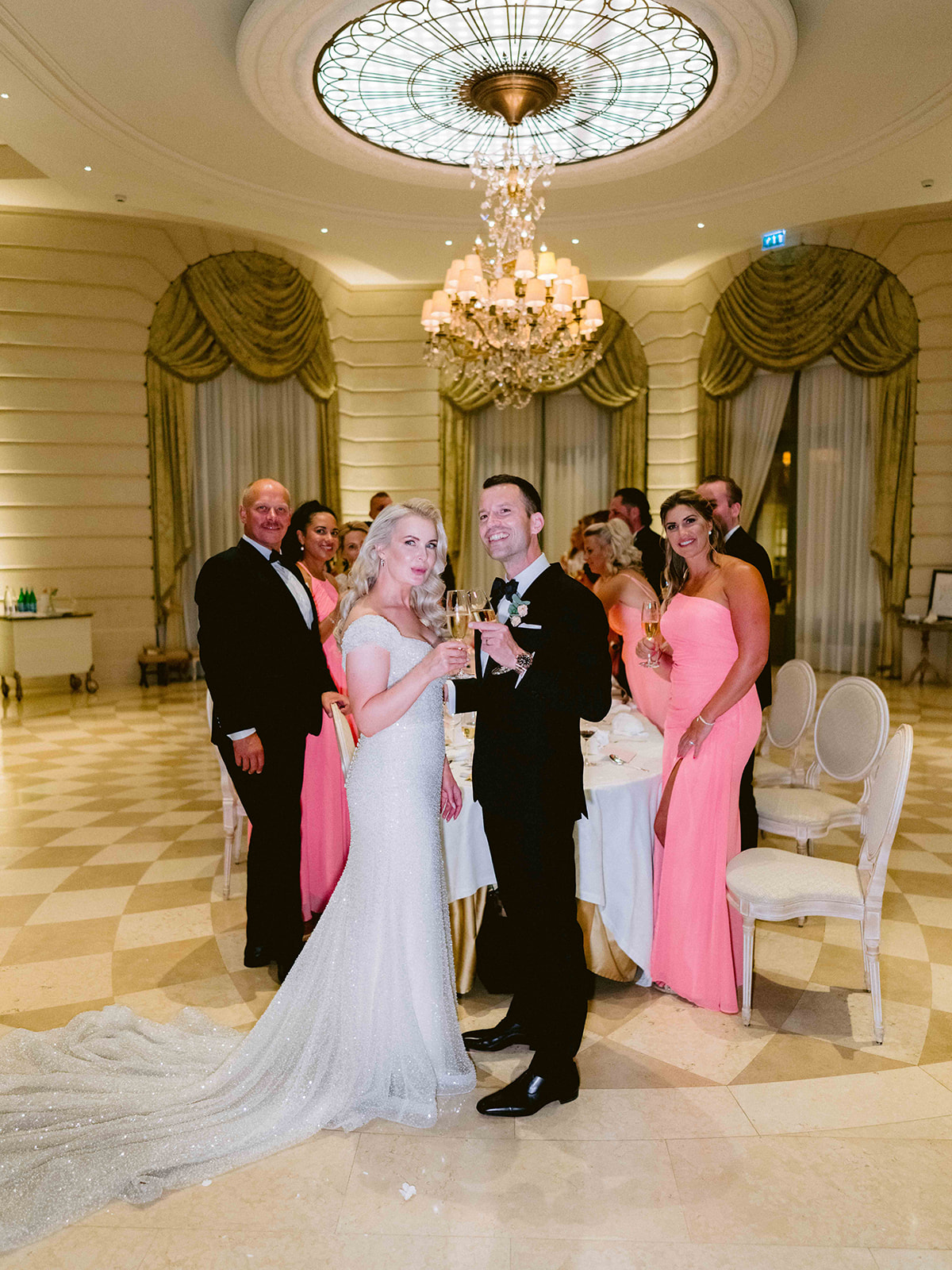 Mariés levant leur coupe de champagne pendant la réception au Ritz Paris