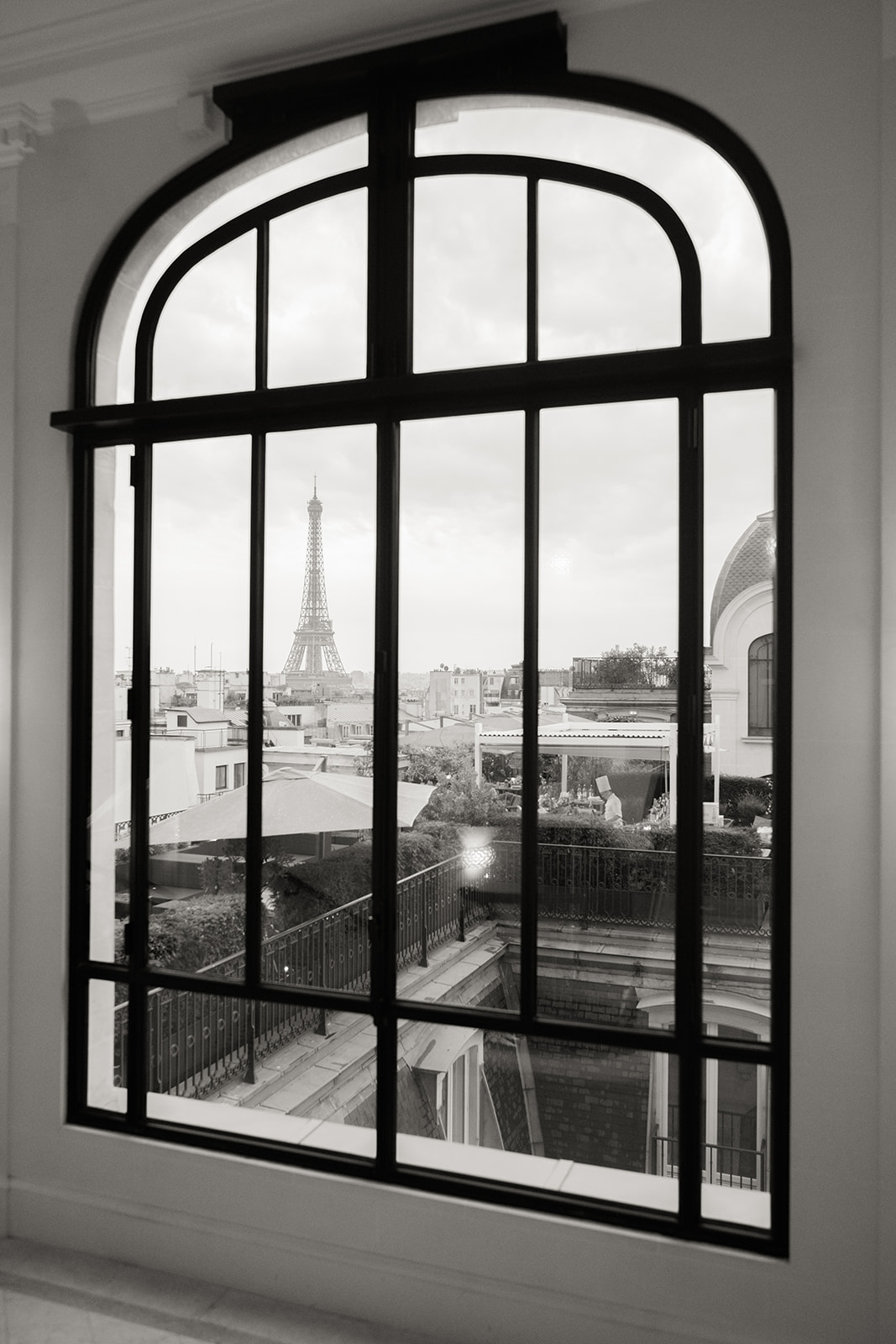 Eiffel Tower view framed by an arched window at The Peninsula Paris