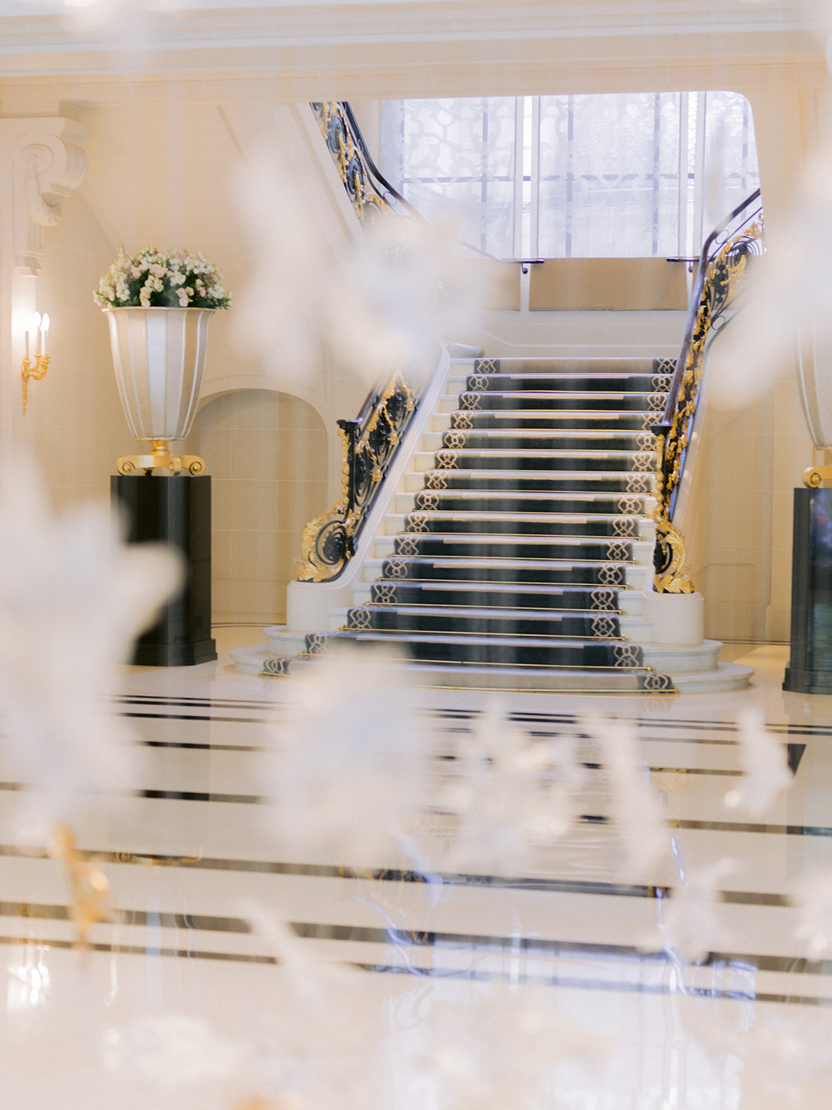Grand staircase and floral arrangements inside The Peninsula Paris