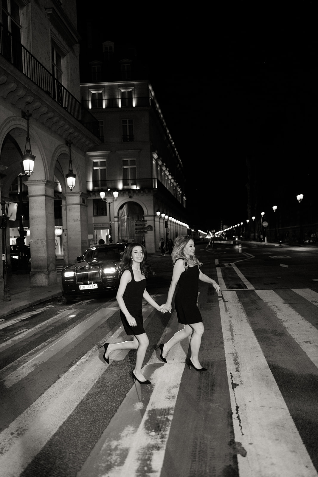 Couple crossing a Paris avenue during their night elopement session