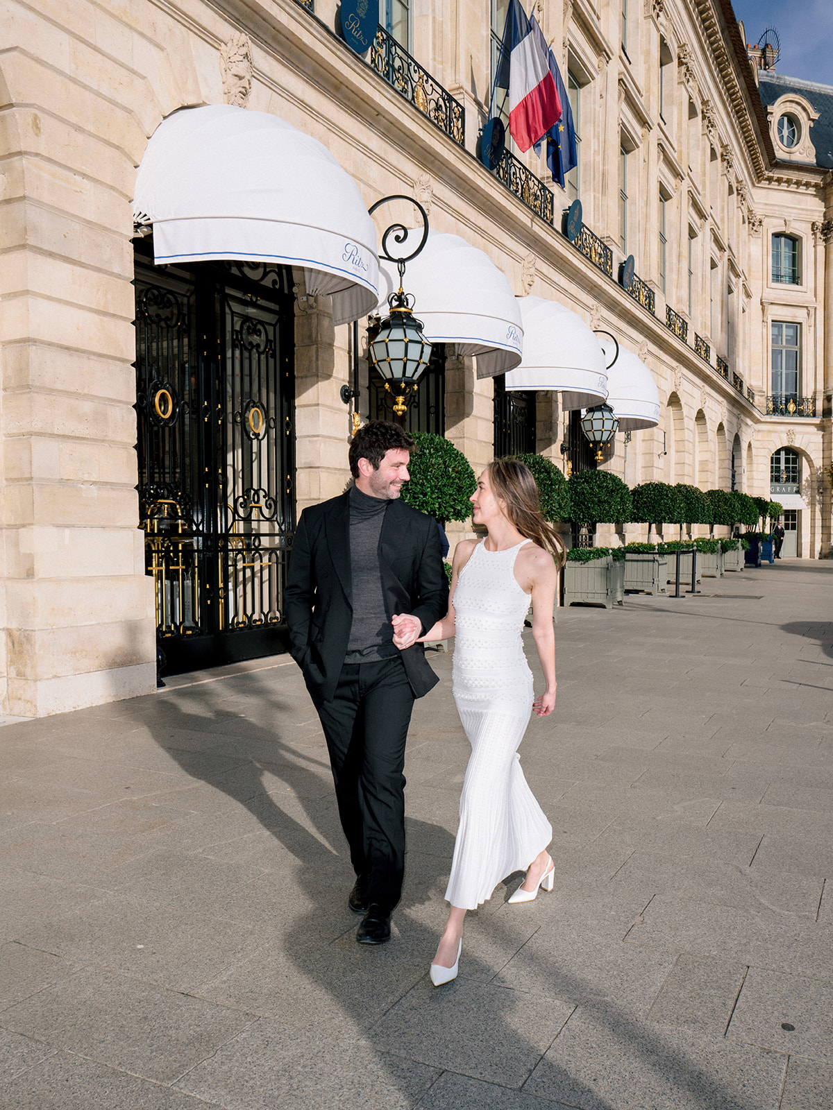 Editorial couple walking together outside the Ritz Paris on Place Vendôme