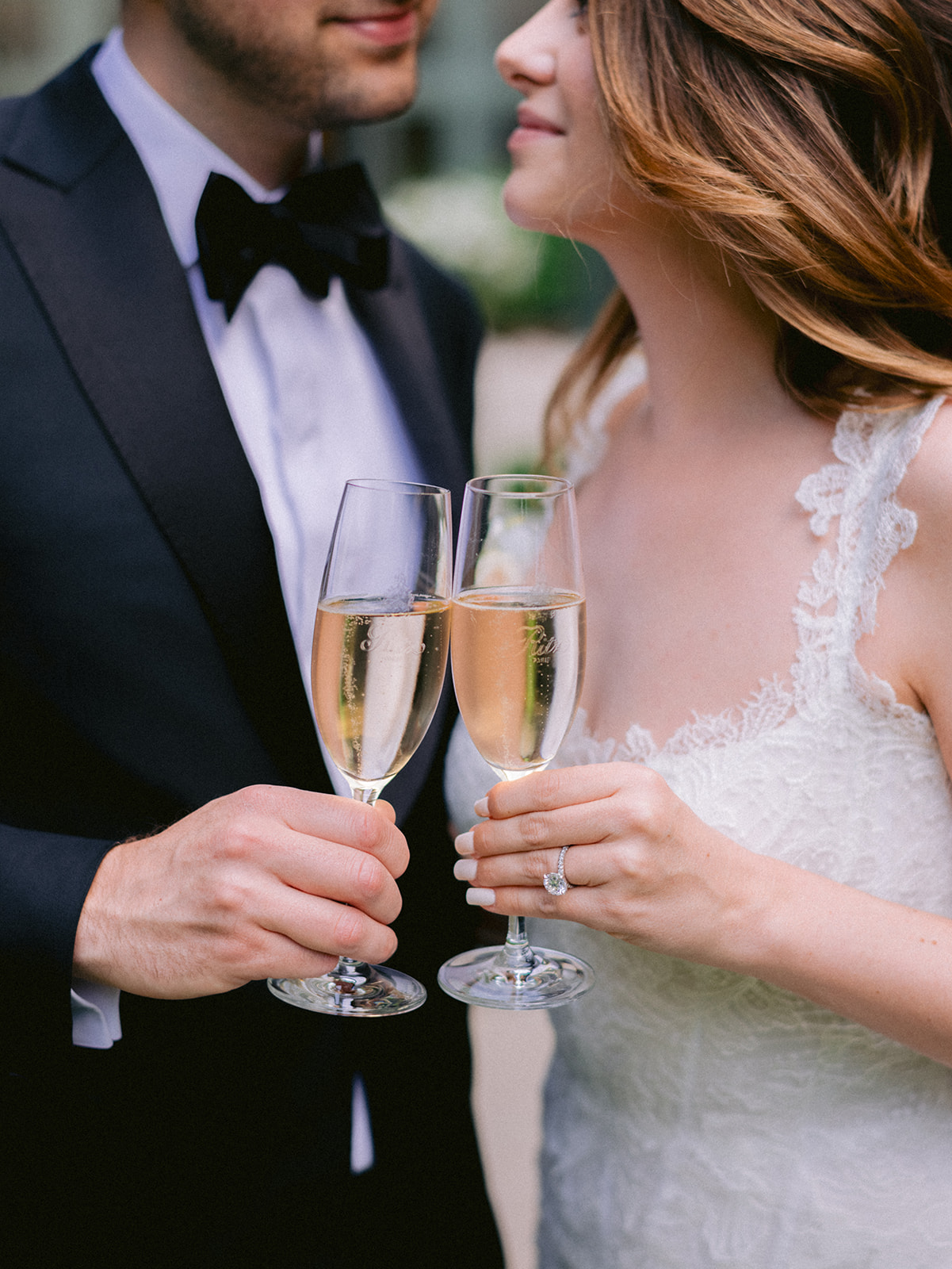 Bride and groom clinking champagne glasses at their luxury Paris wedding