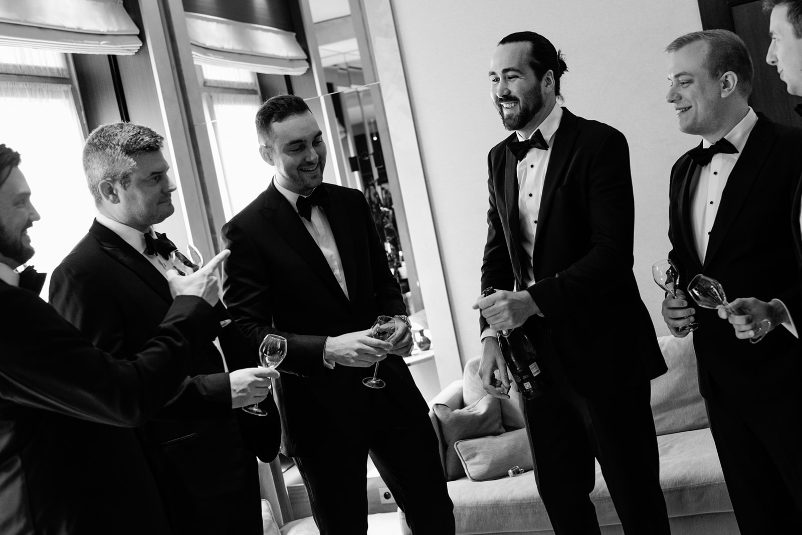 Groomsmen sharing a spontaneous black-tie moment at the Ritz Paris