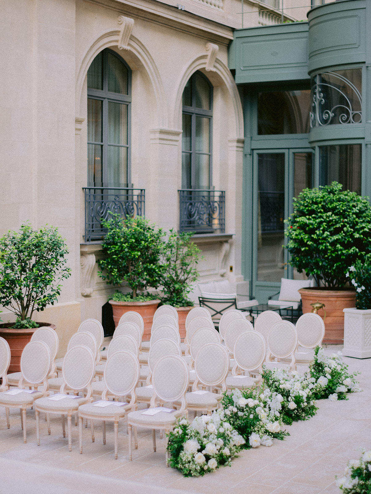 Elegant ceremony seating and white floral aisle at a Paris palace wedding