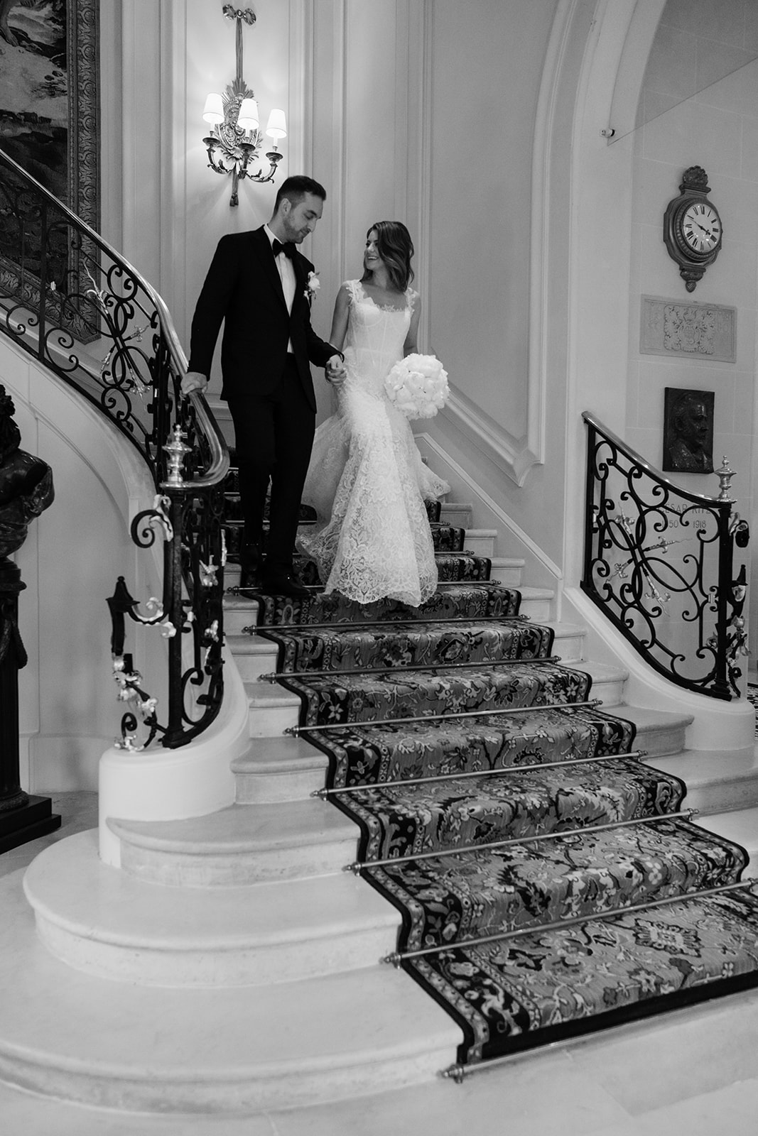 Newlyweds posing on the grand staircase during their Ritz Paris wedding