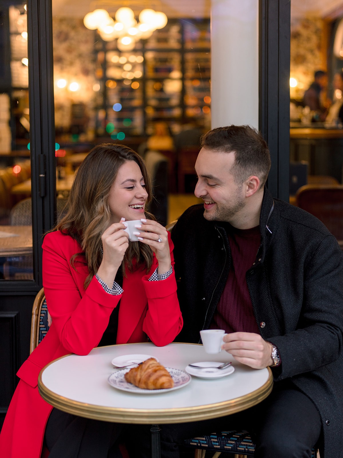 Couple sharing coffee at a Paris cafe during their pre-wedding session