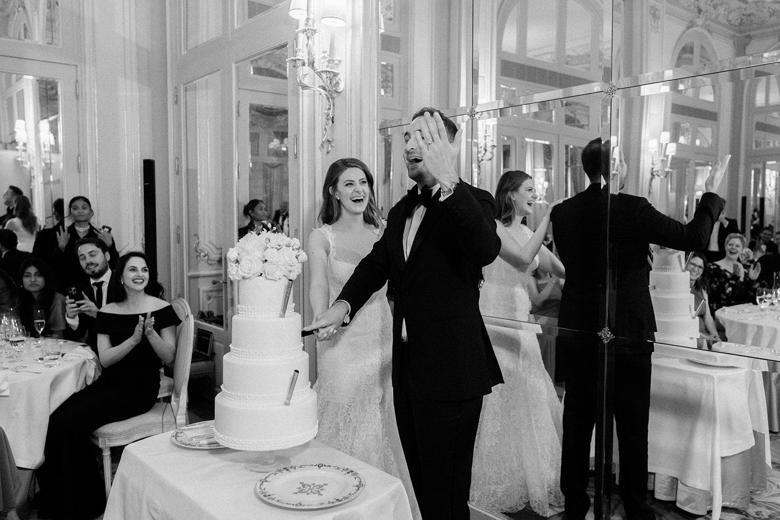 Bride and groom cutting their tiered wedding cake at a luxury Paris reception