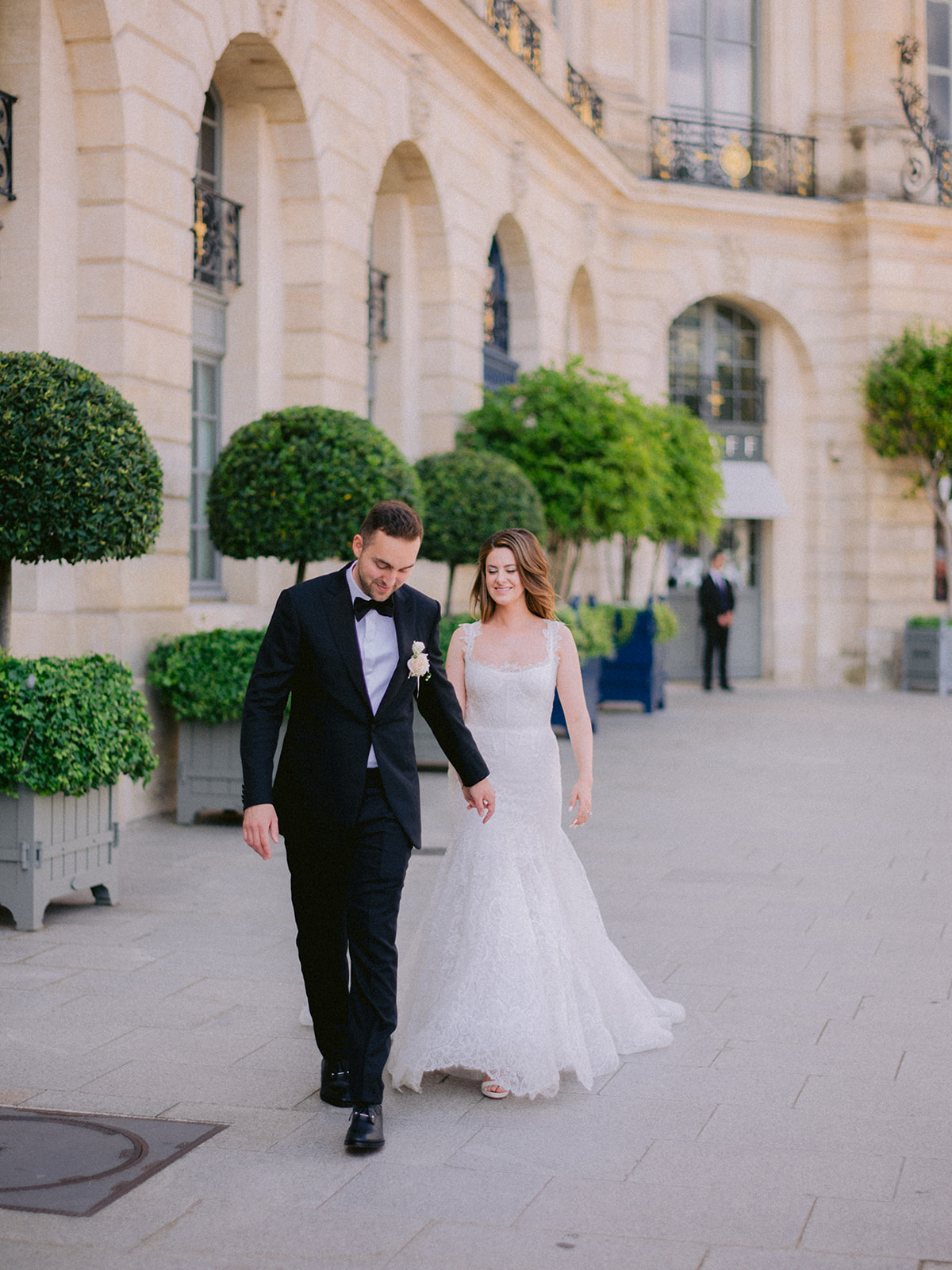 Bride and groom walking outside a Paris palace after their wedding ceremony