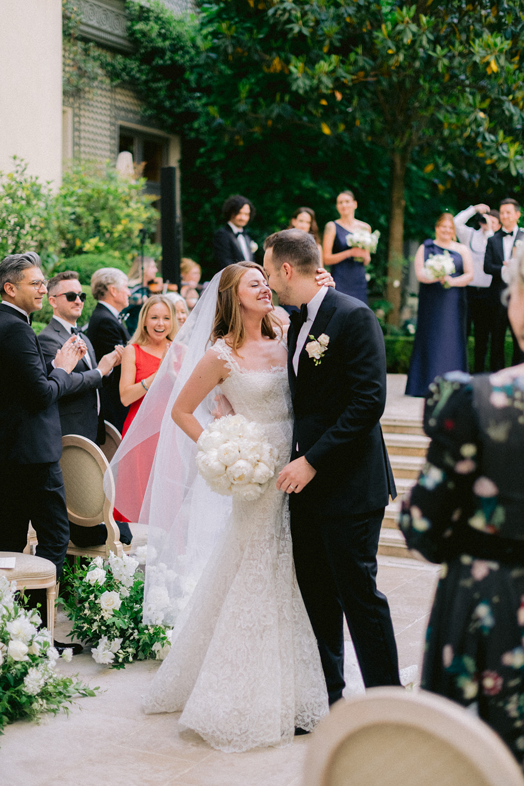Newlyweds kissing after their outdoor wedding ceremony in Paris