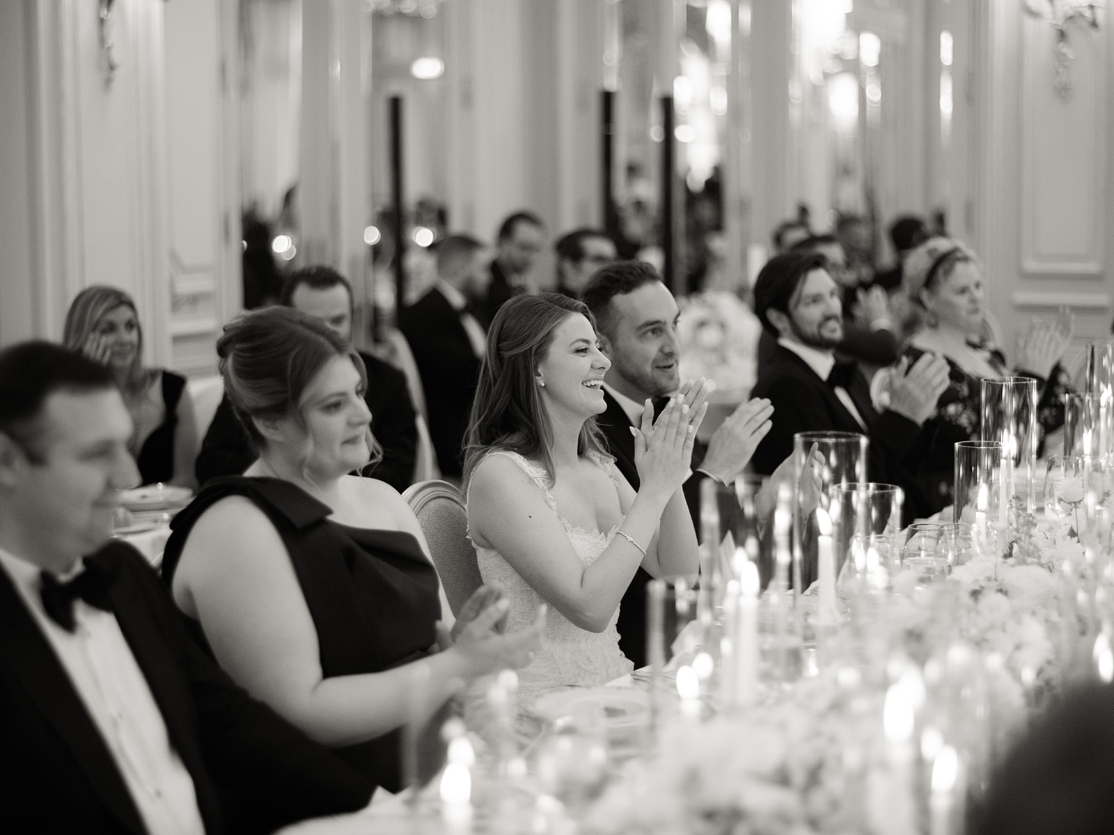 Bride and guests applauding during wedding reception speeches in Paris
