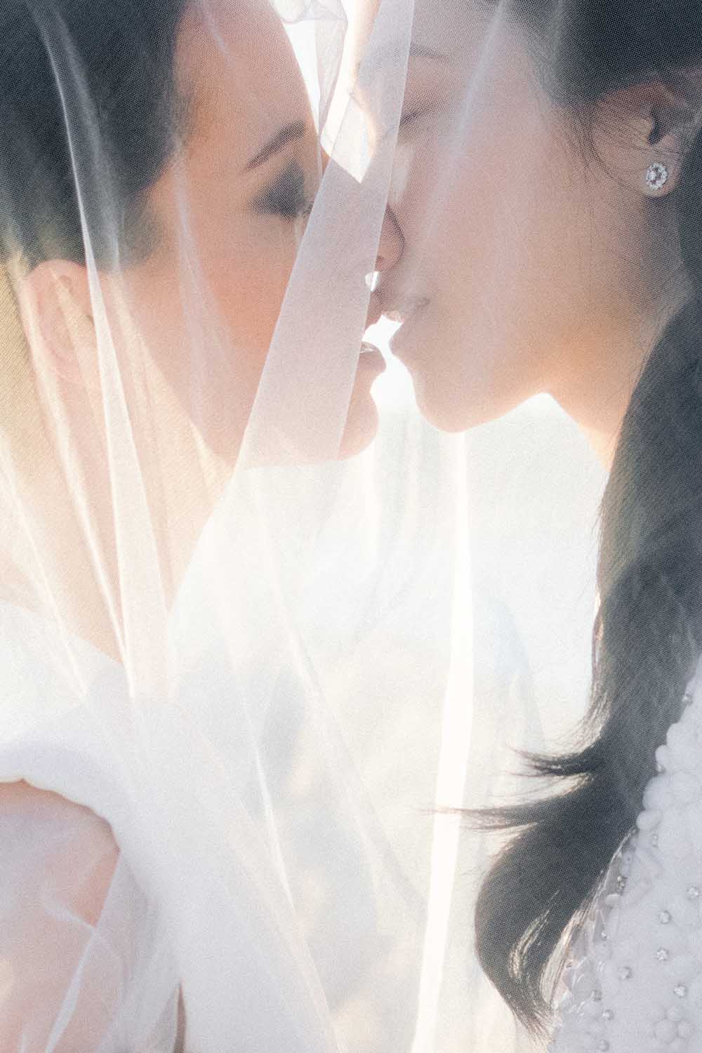 deux femmes s embrassent sous un voile de mariée