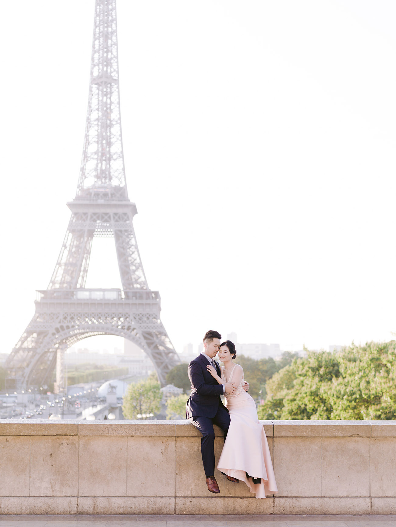 le couple est heureux et se prend dans les bras face à la tour eiffel