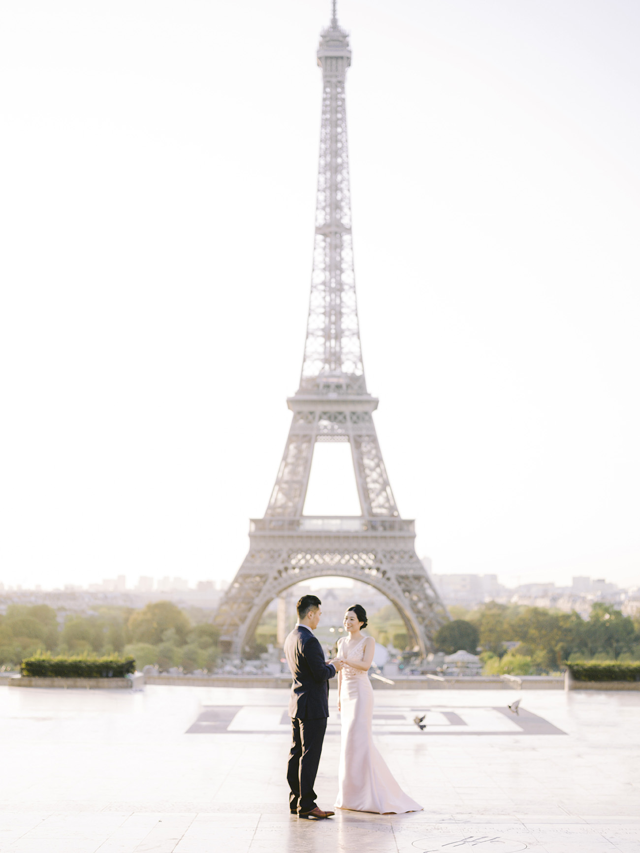 Happy couple celebrating their love with a kiss in front of the iconic Eiffel Tower. Perfect inspiration for any intimate wedding