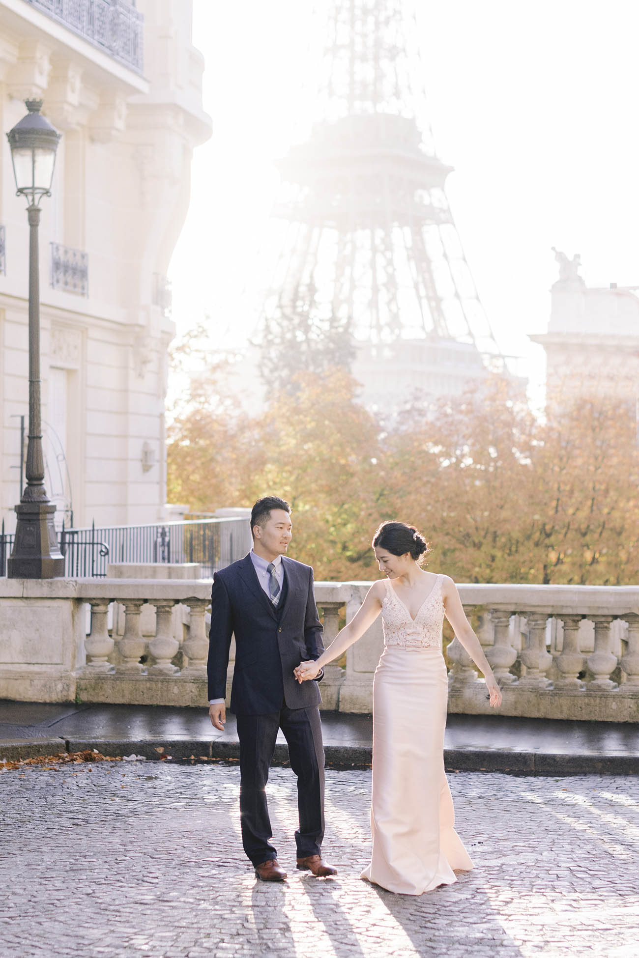 un couple marche derirere eux on voit la tour eiffel