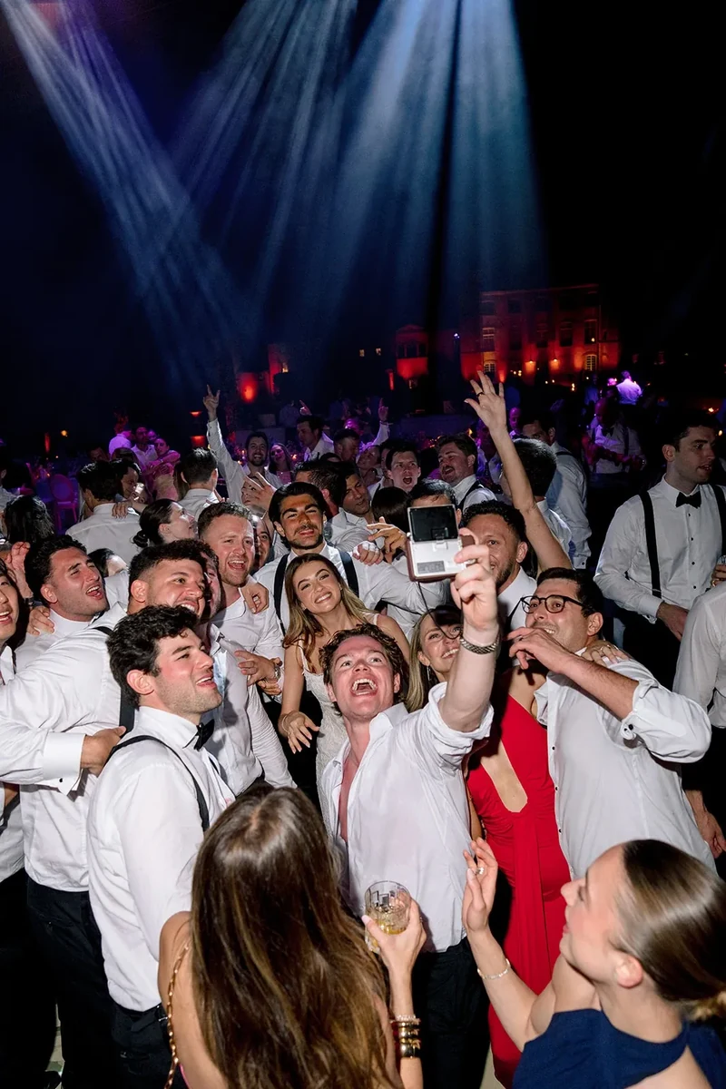 Les invités prennent un selfie de groupe sur la piste de danse pendant la fête du mariage