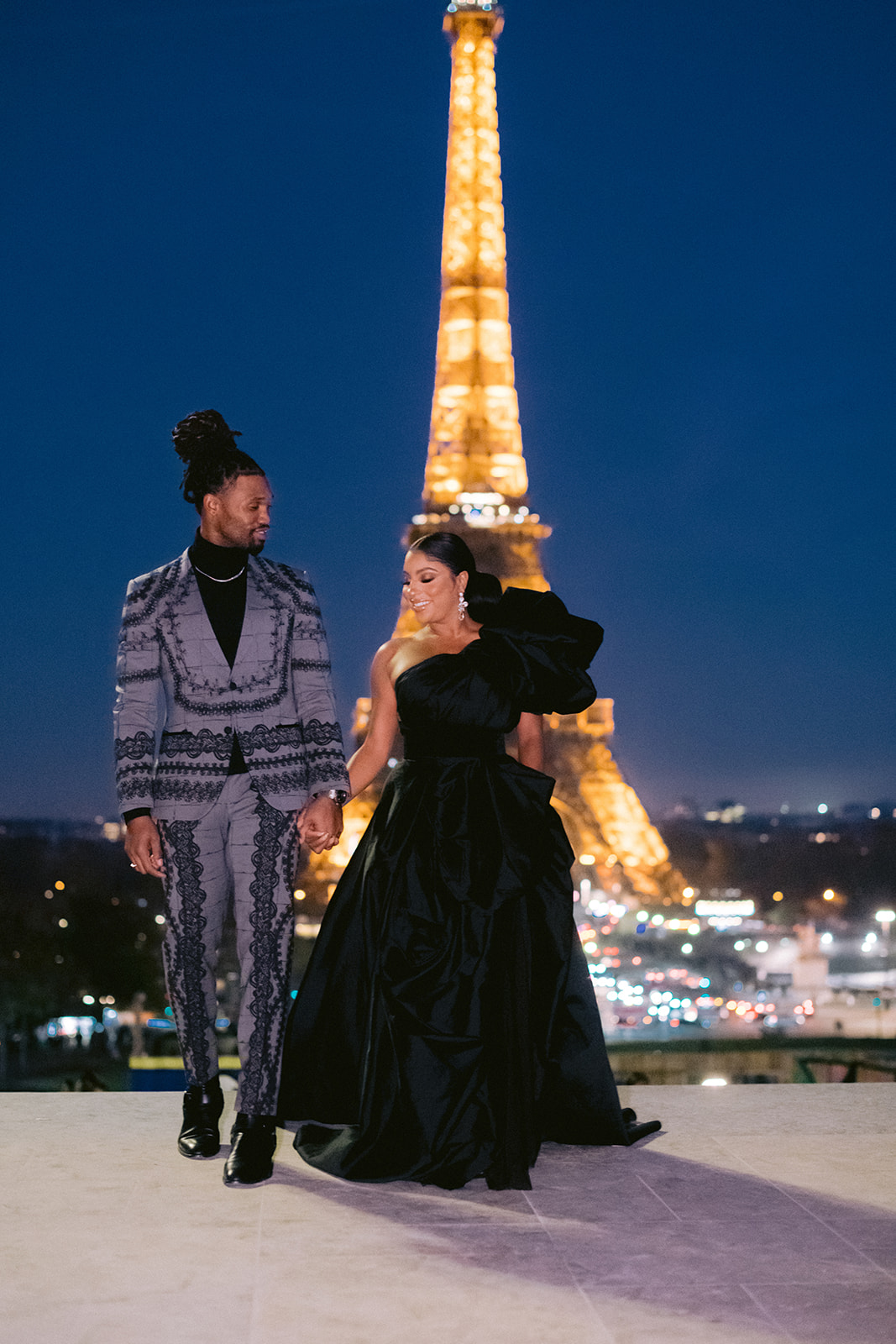 the couple walk in the trocadero face the eiffel tower