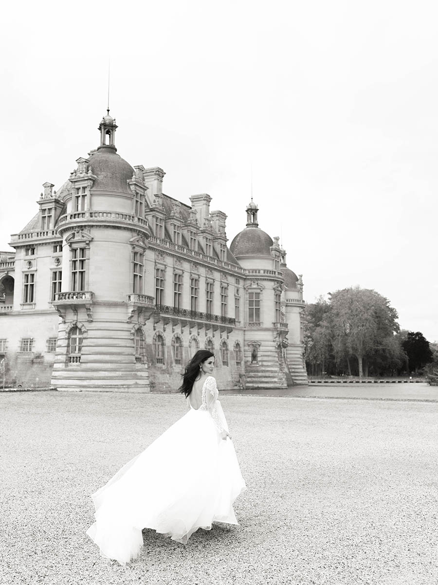 une mariée marche dans les jardins du chateau