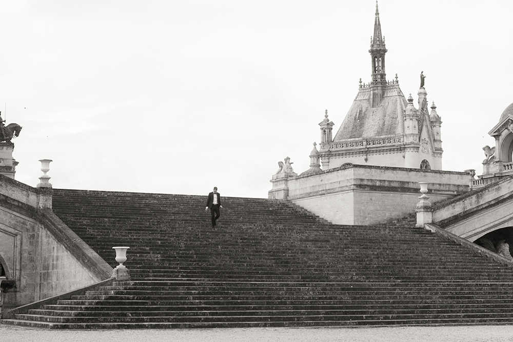 un homme descend de grand marches du chateau de chantilly