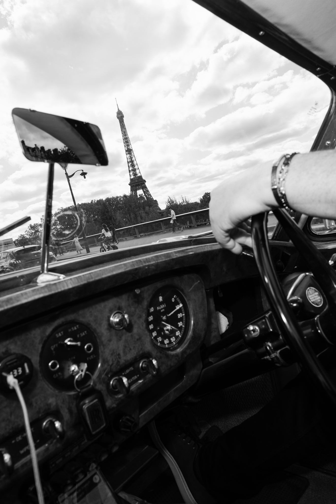 Black-and-white view of the Eiffel Tower from a vintage car in Paris