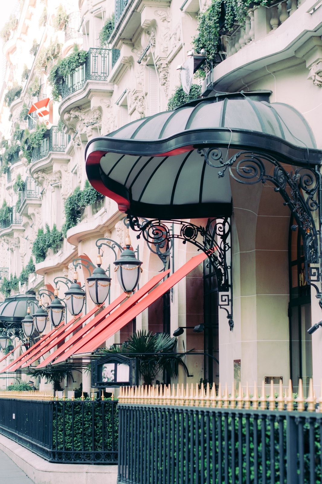Red awnings and entrance canopy along the façade of Hôtel Plaza Athénée in Paris