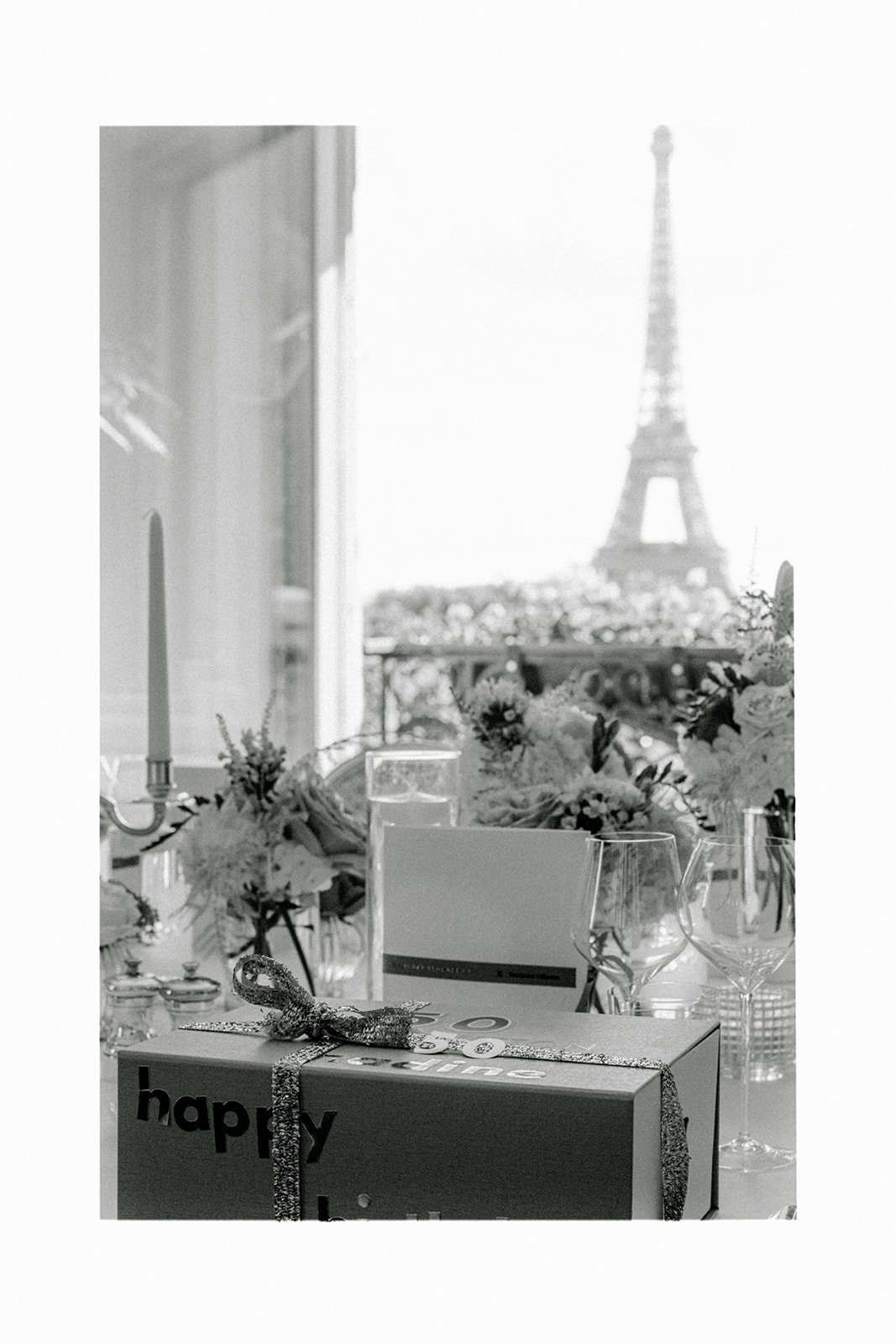 Black-and-white photograph of a private birthday table facing the Eiffel Tower at Plaza Athénée