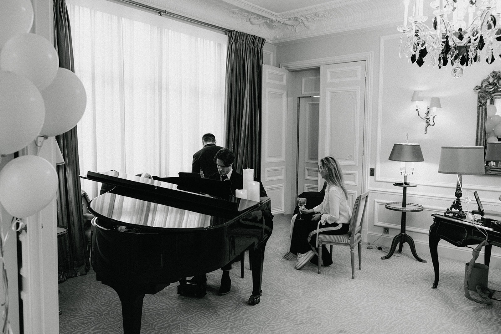 Black-and-white wide view of live piano music inside the Haute Couture Eiffel Suite at Hôtel Plaza Athénée