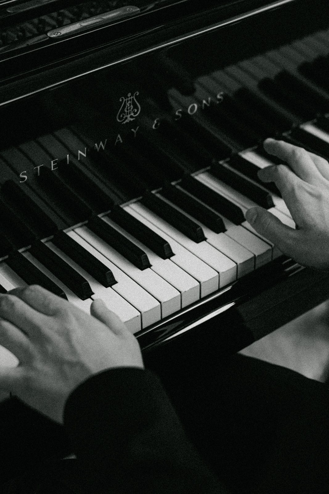Black-and-white detail of a pianist at a private event inside Hôtel Plaza Athénée Paris