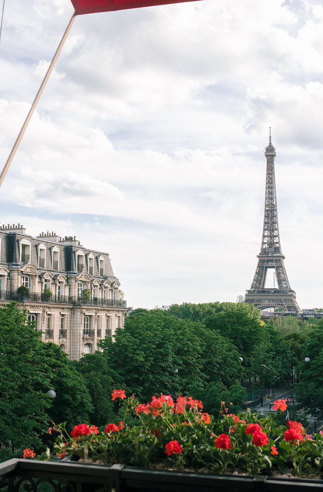 Eiffel Tower view from a flower-lined balcony at Hôtel Plaza Athénée Paris