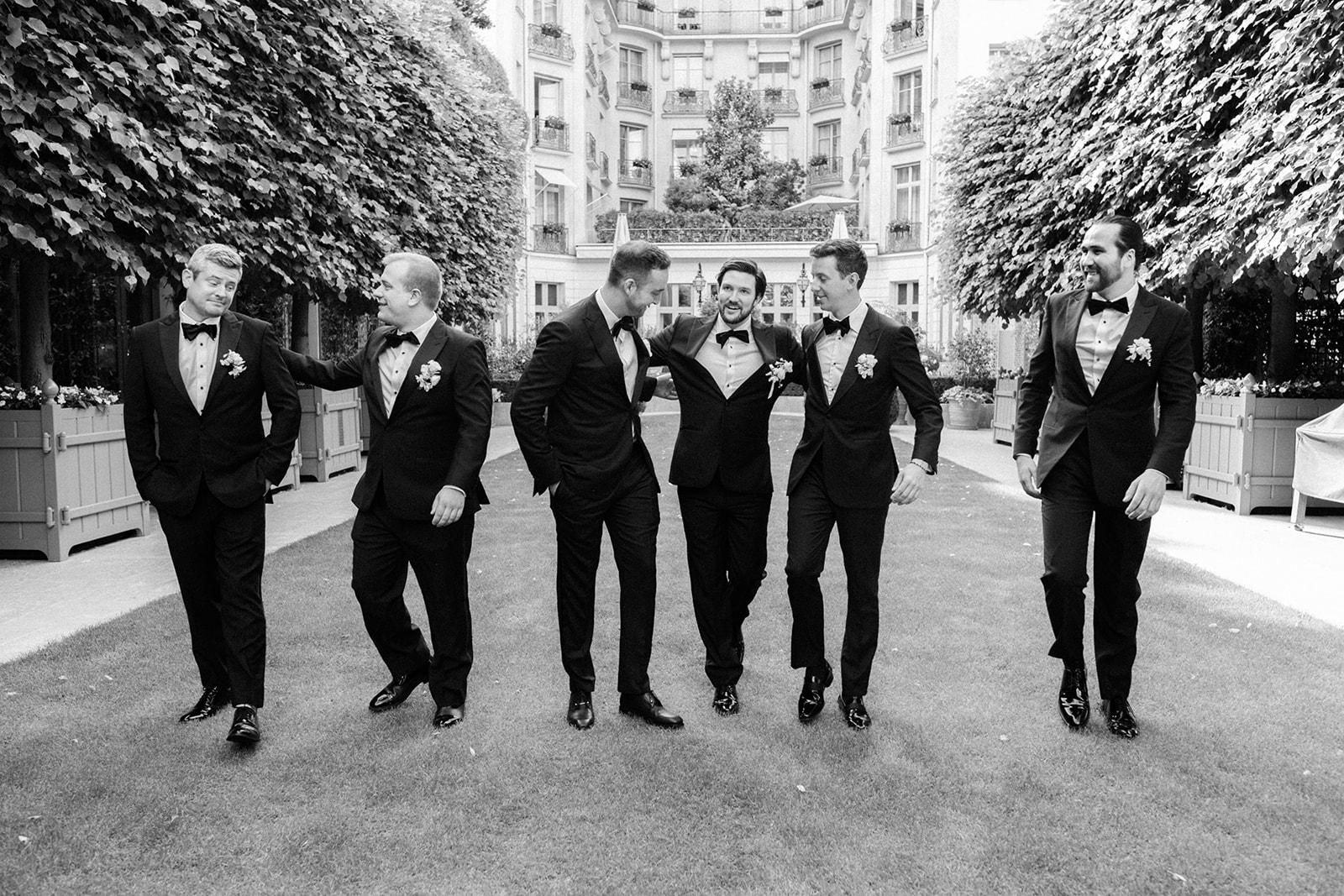 Gar&ccedil;ons d&rsquo;honneur marchant dans le jardin du Ritz Paris en tenue de soir&eacute;e