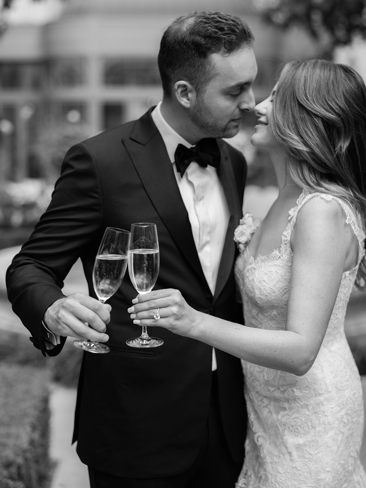Portrait noir et blanc des mari&eacute;s avec des coupes de champagne au Ritz Paris