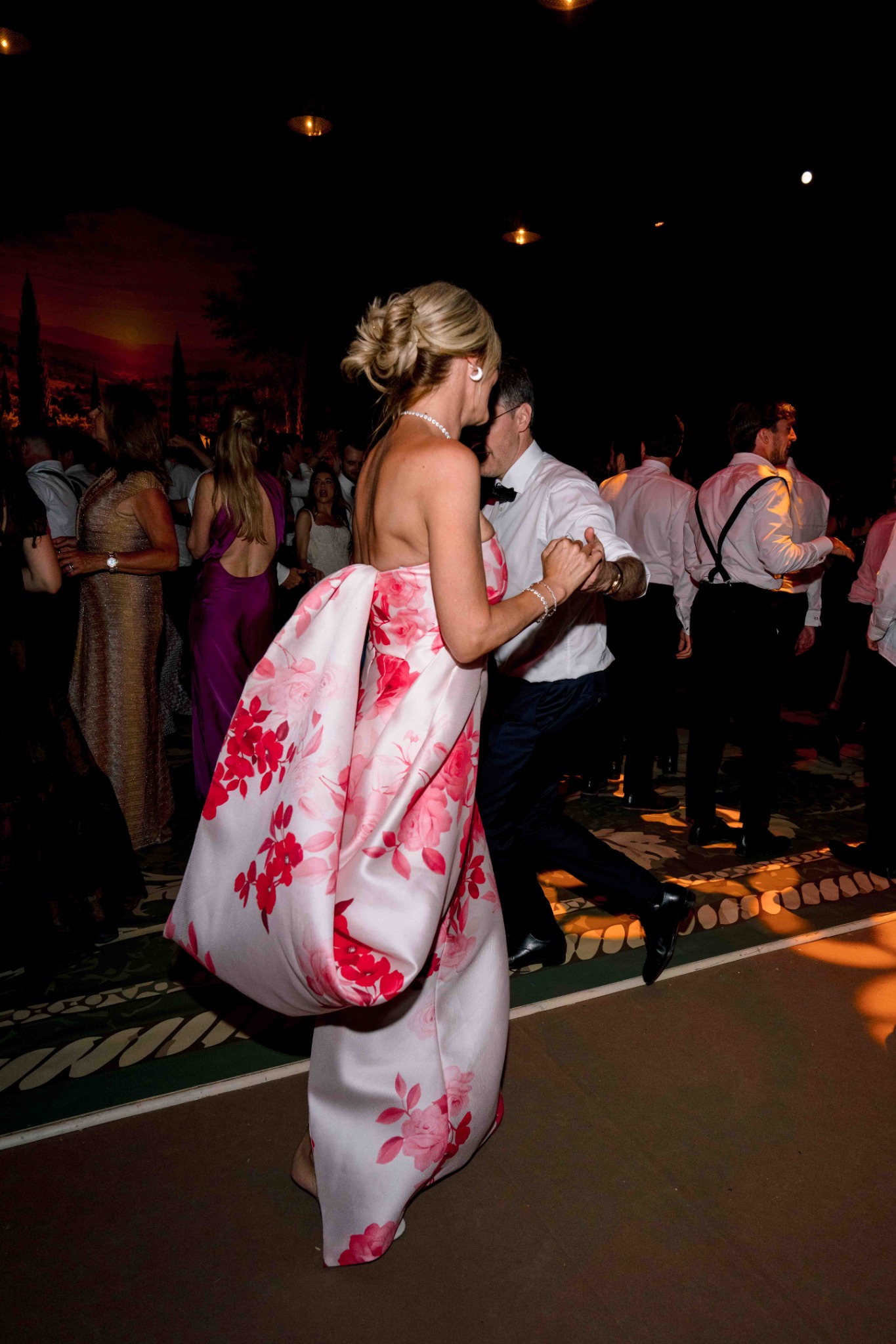 Wedding guest dancing in an elegant floral gown at Villa Baulieu