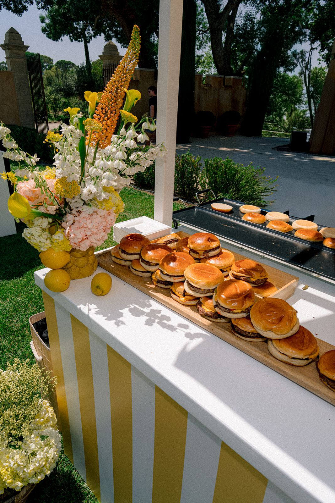 Gourmet burger station beside a post-wedding pool party