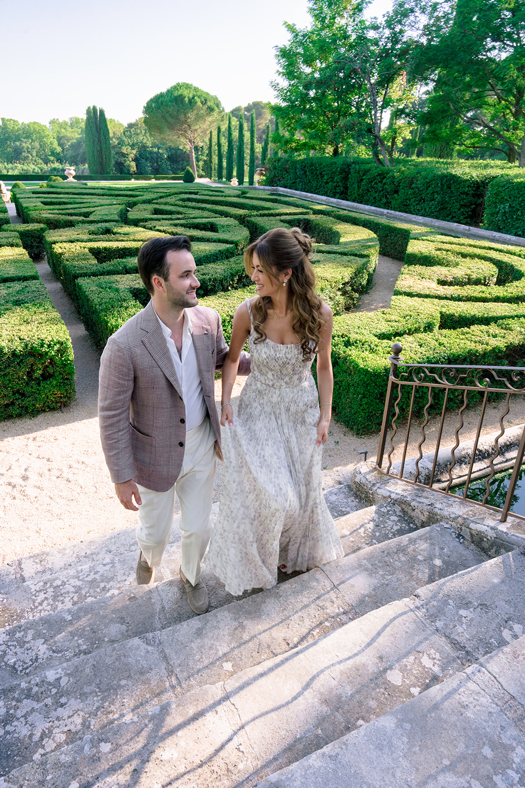 Newlyweds walking through the formal gardens at Villa Baulieu in Provence