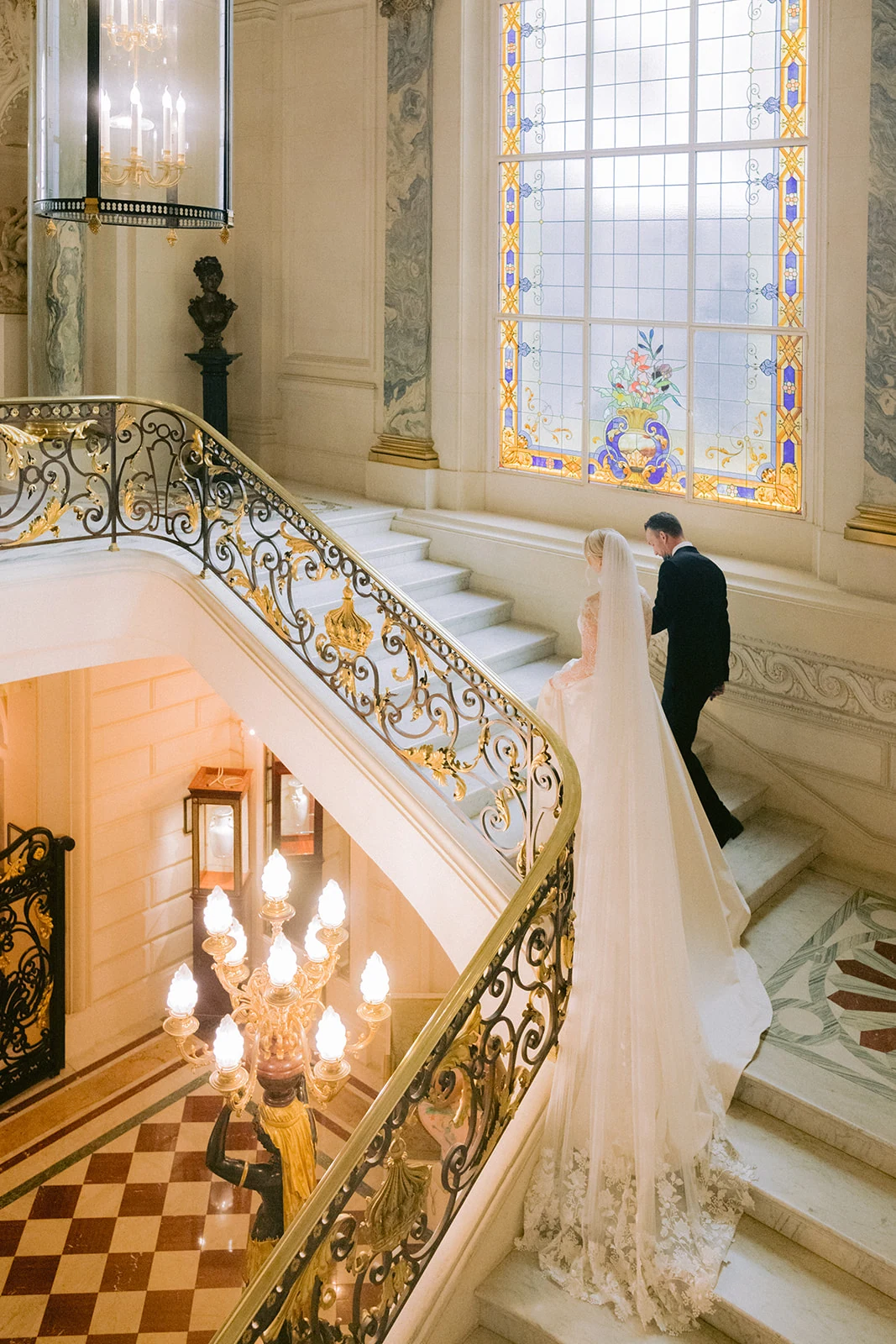 Bride and groom walking up the grand staircase at Shangri-La Paris