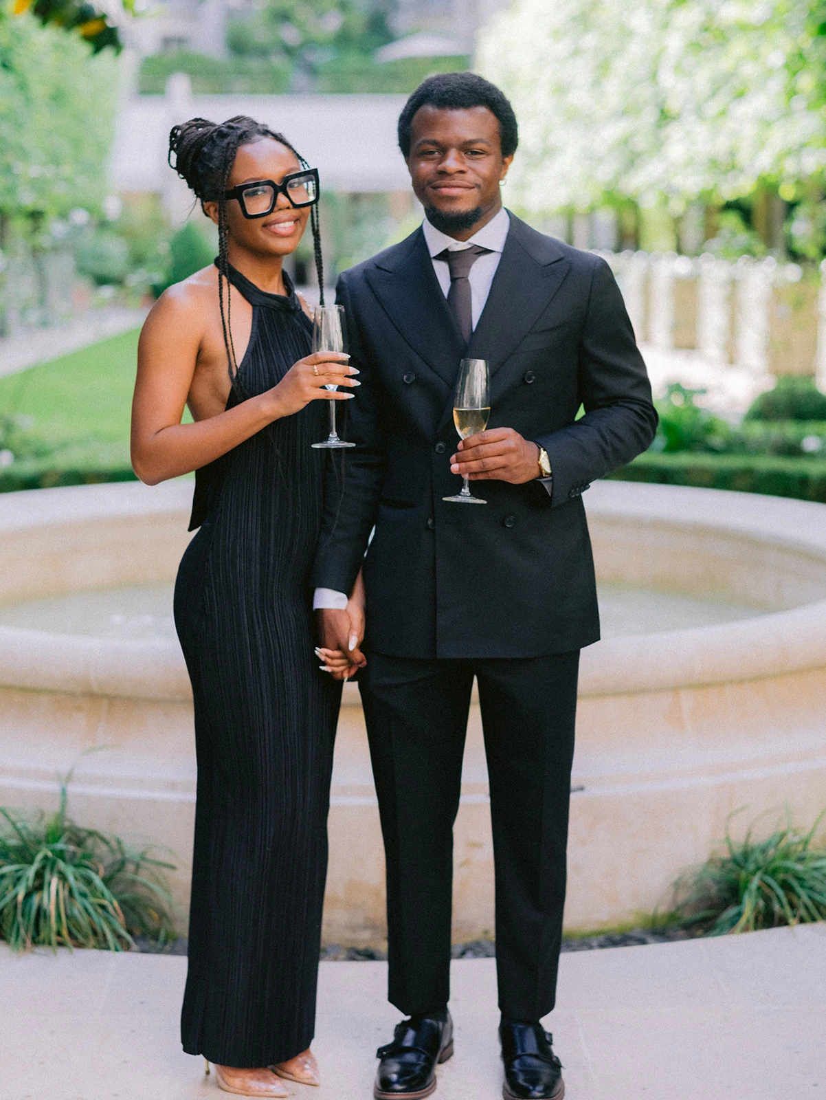 Fashionable wedding guests holding champagne during cocktail hour in Paris