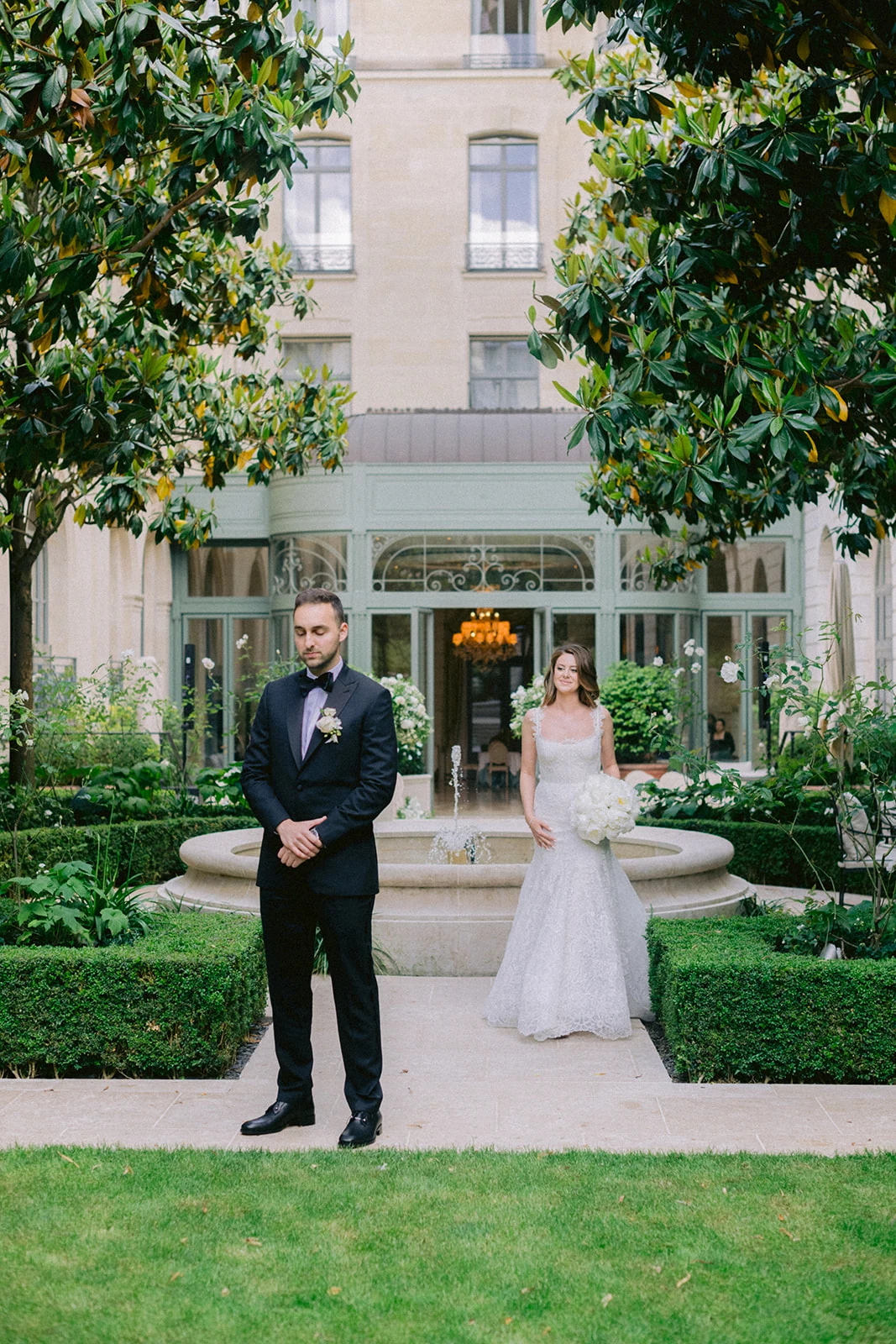 Bride approaching the groom for a first look in a private Paris garden