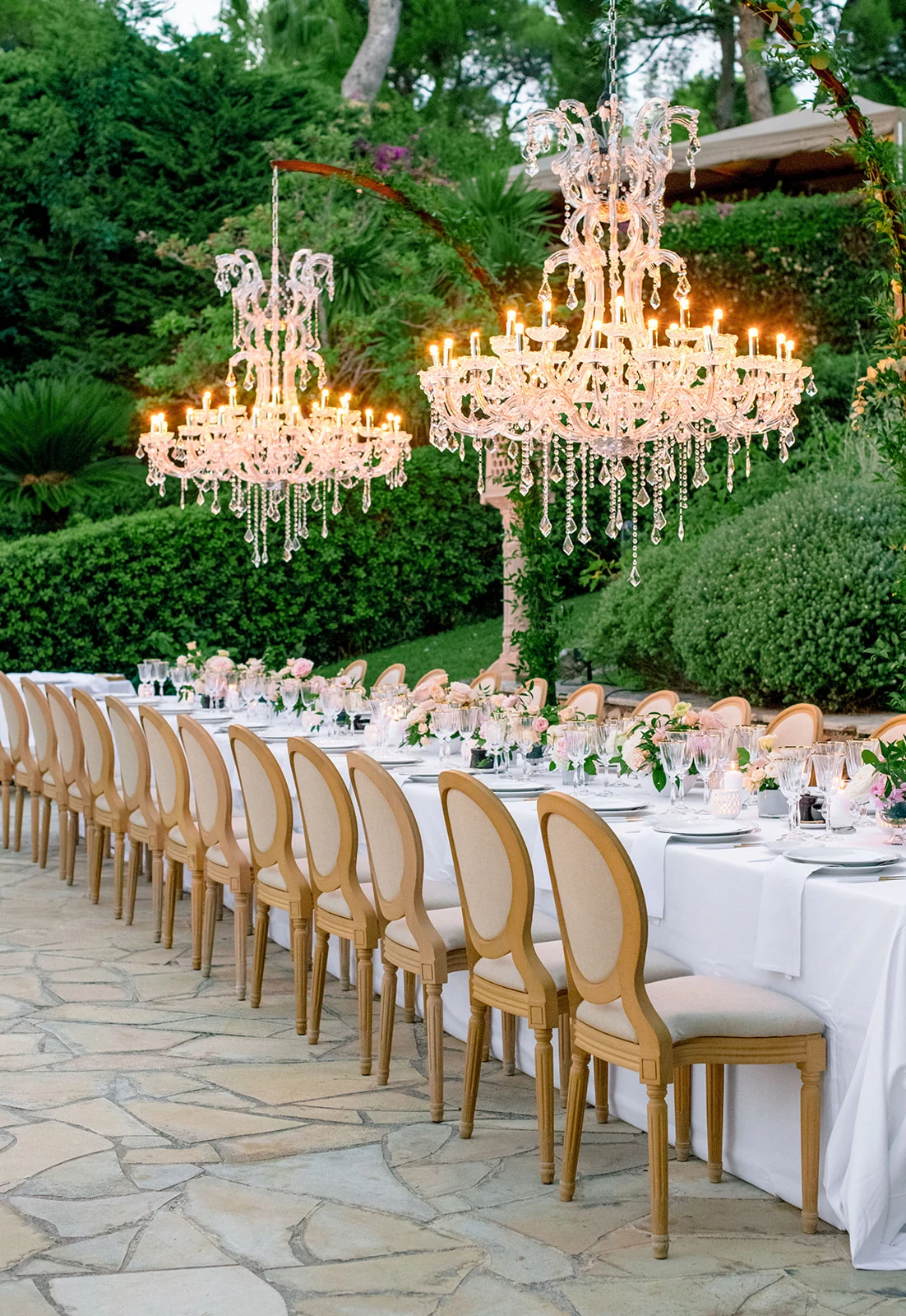 A long outdoor dinner or ceremony in early-summer light.