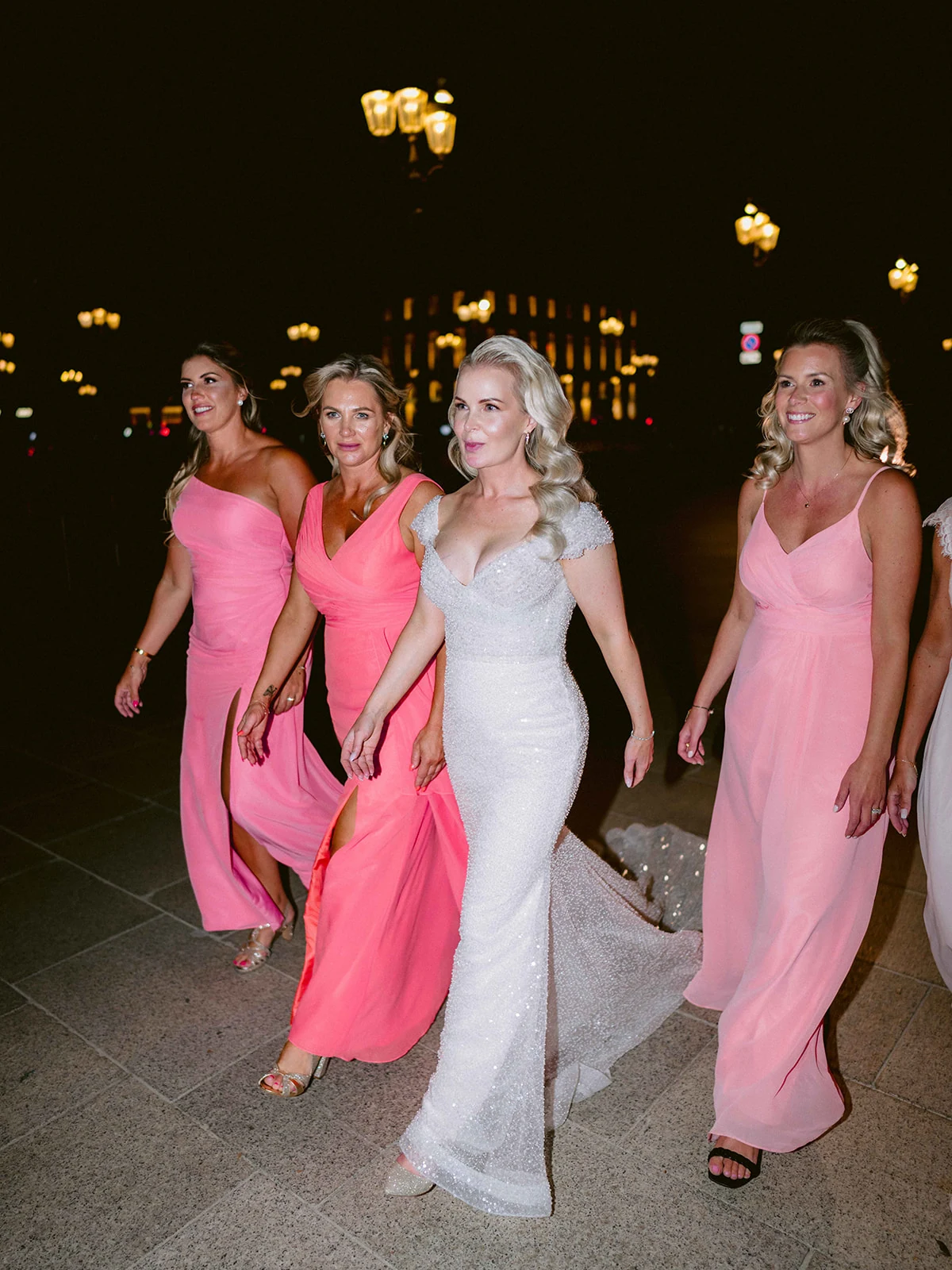 Bride walking through Paris at night with her bridesmaids after the Ritz reception