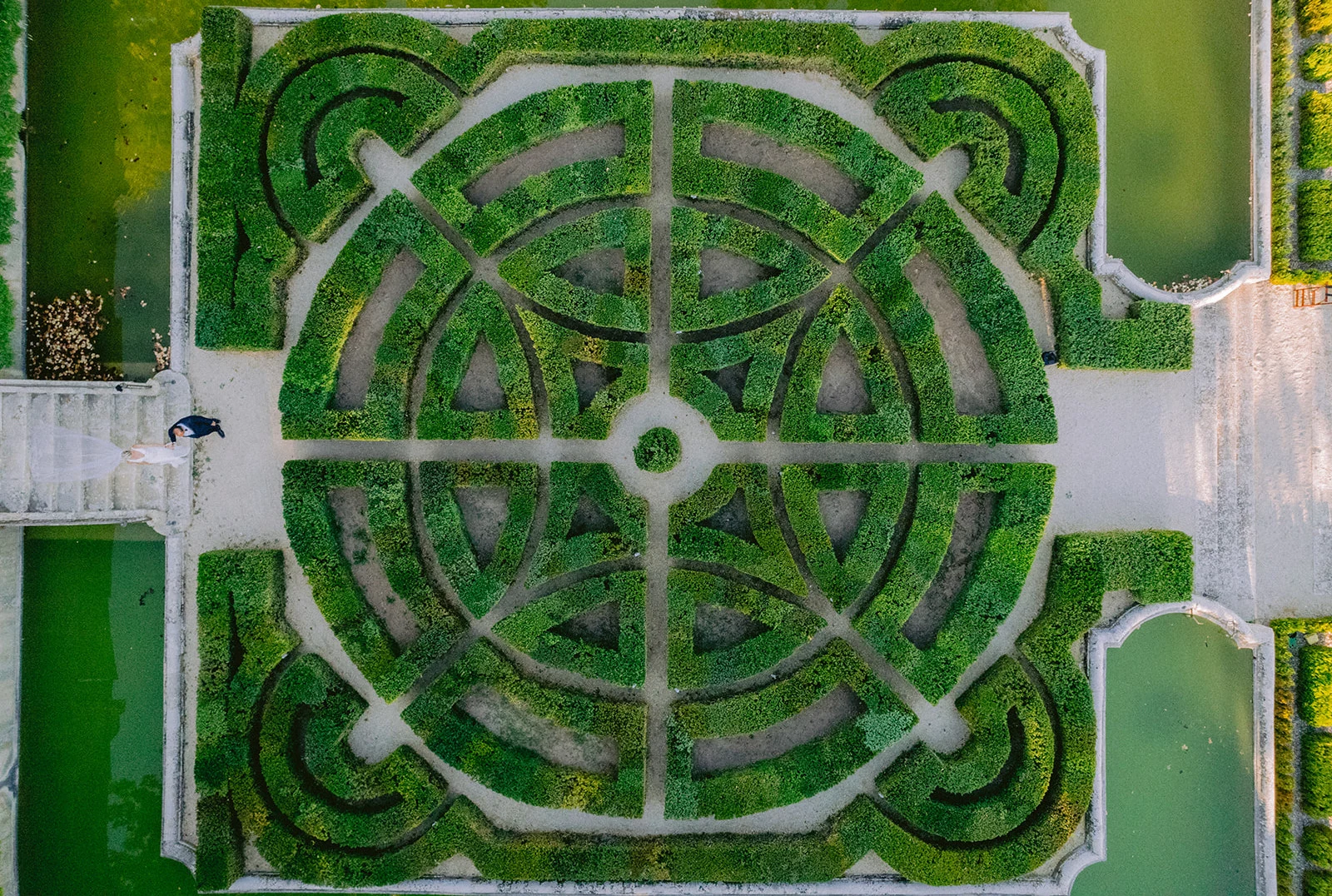 Aerial view of a bride and groom walking through the gardens of Château de la Gaude