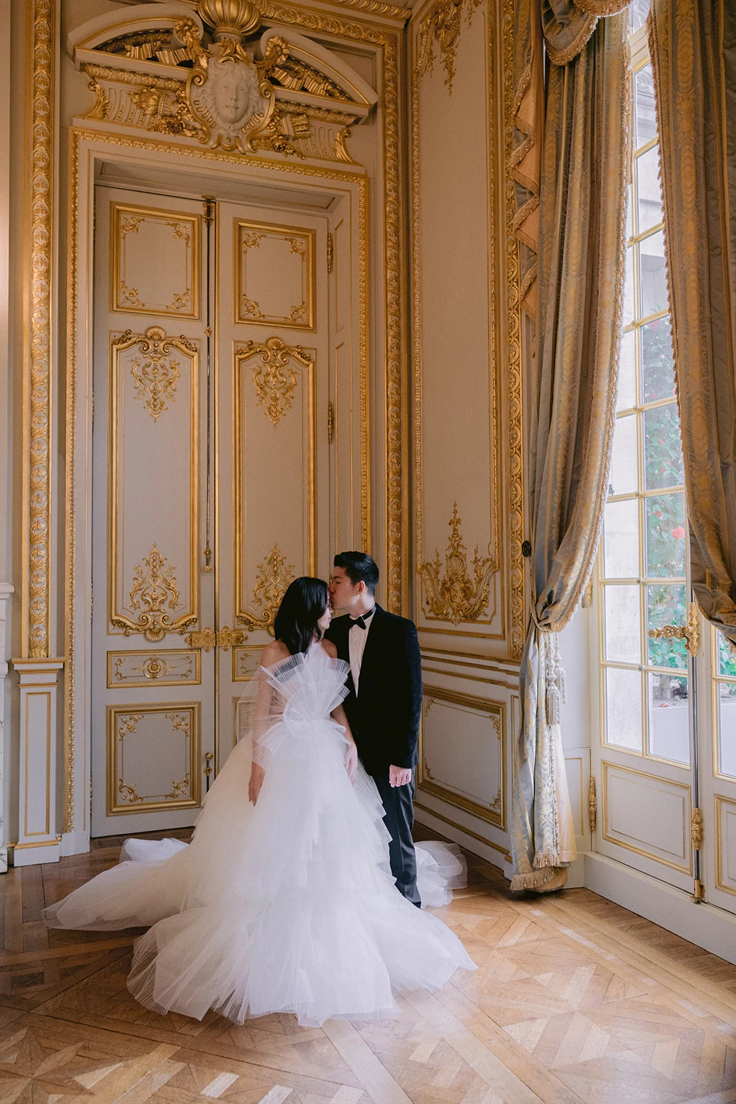 Couple kissing by a palace window during a Shangri-La Paris photo session