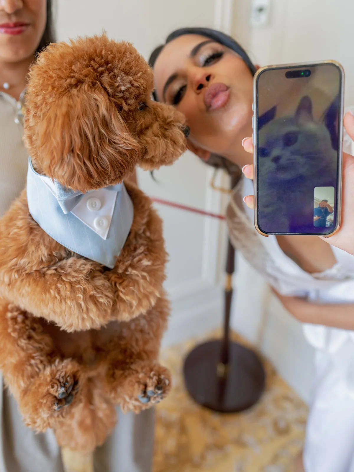 Bride sharing a playful FaceTime moment with her dog during wedding preparations at Shangri-La Paris